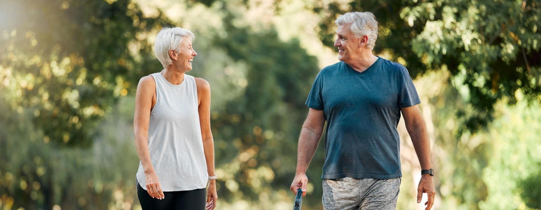 a man and a woman walking a dog on a leash