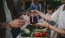 a group of people at a table with food and a blender