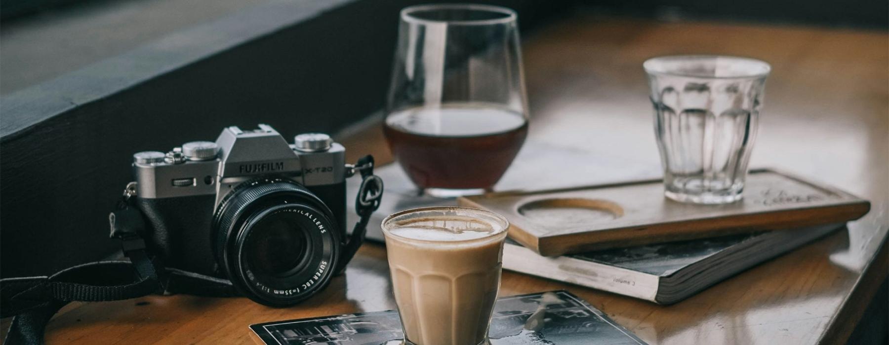 a camera and cup of coffee on a table